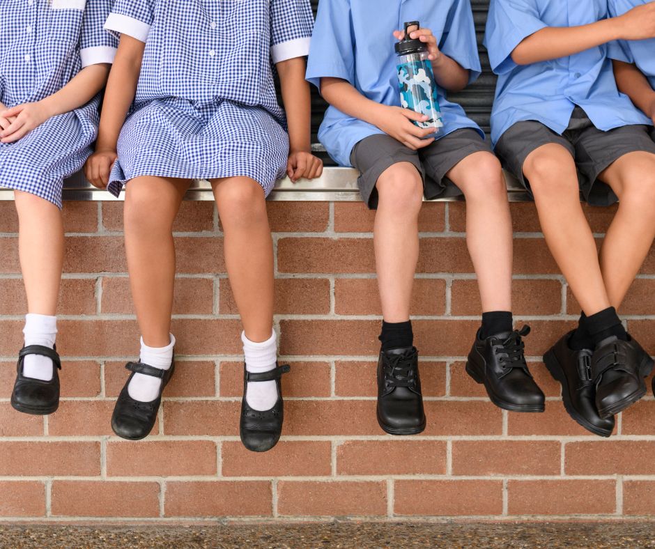 spring real estate market School children sitting on a wall
