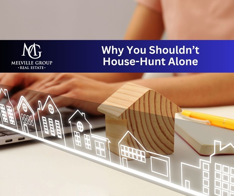 A woman is sitting at a laptop, house-hunting online